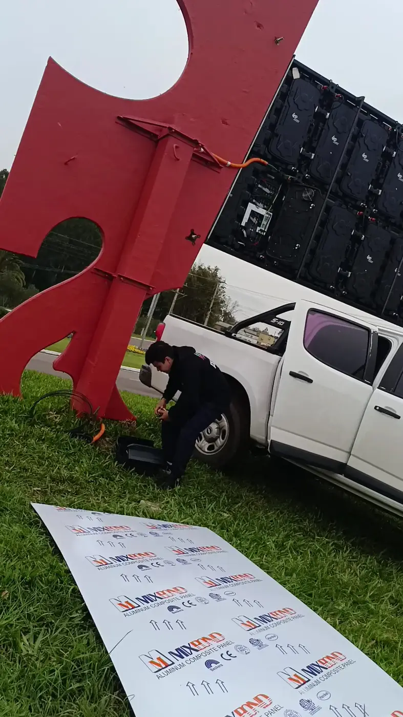 Equipe da LED Outdoor montando a estrutura e os módulos de um painel de LED